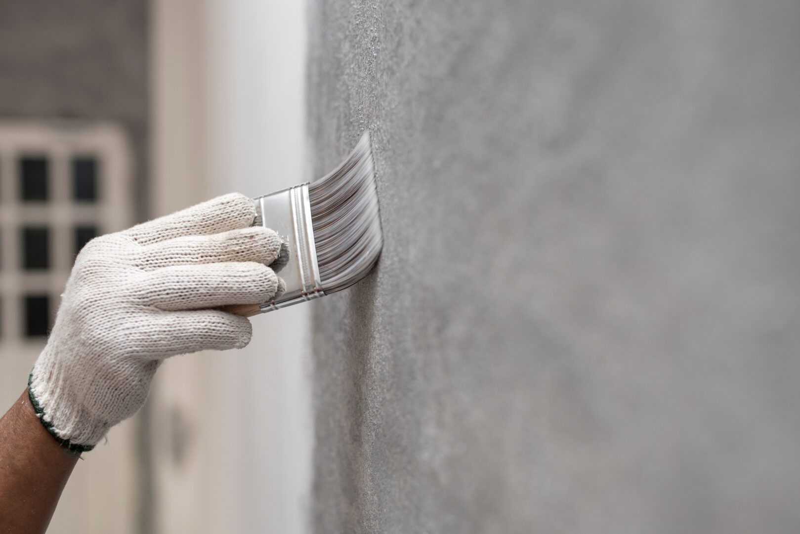 painting a wall with a paint brush