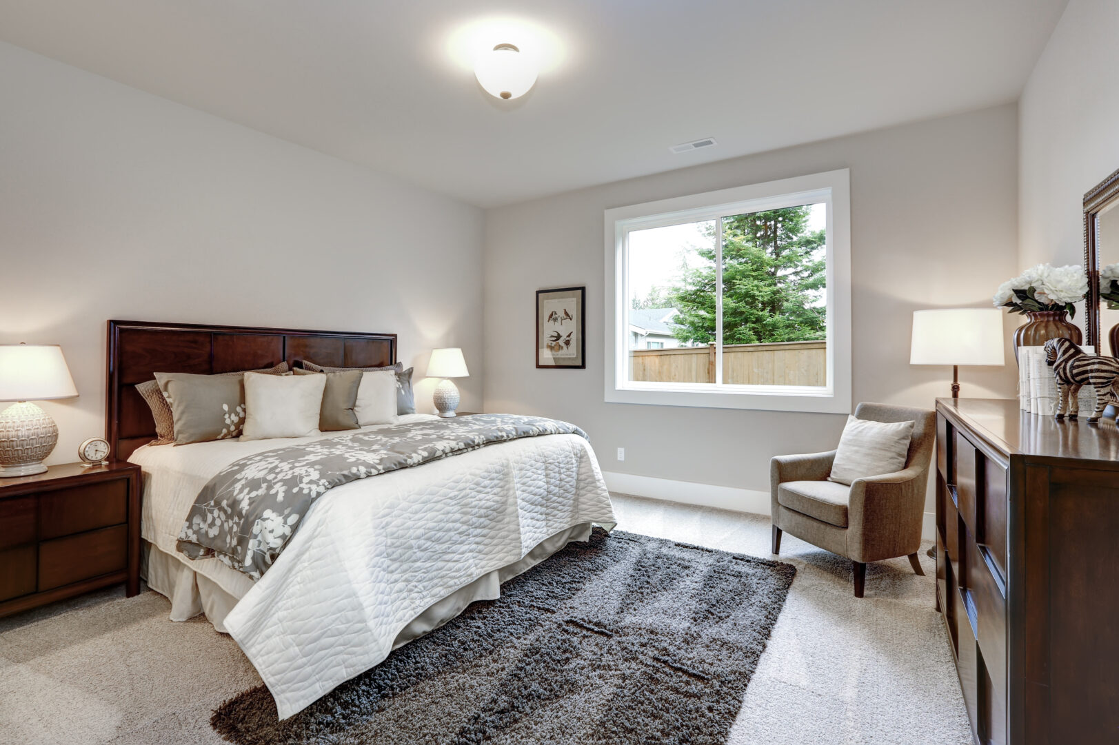 Light modern master bedroom interior with darkwood bed and dress