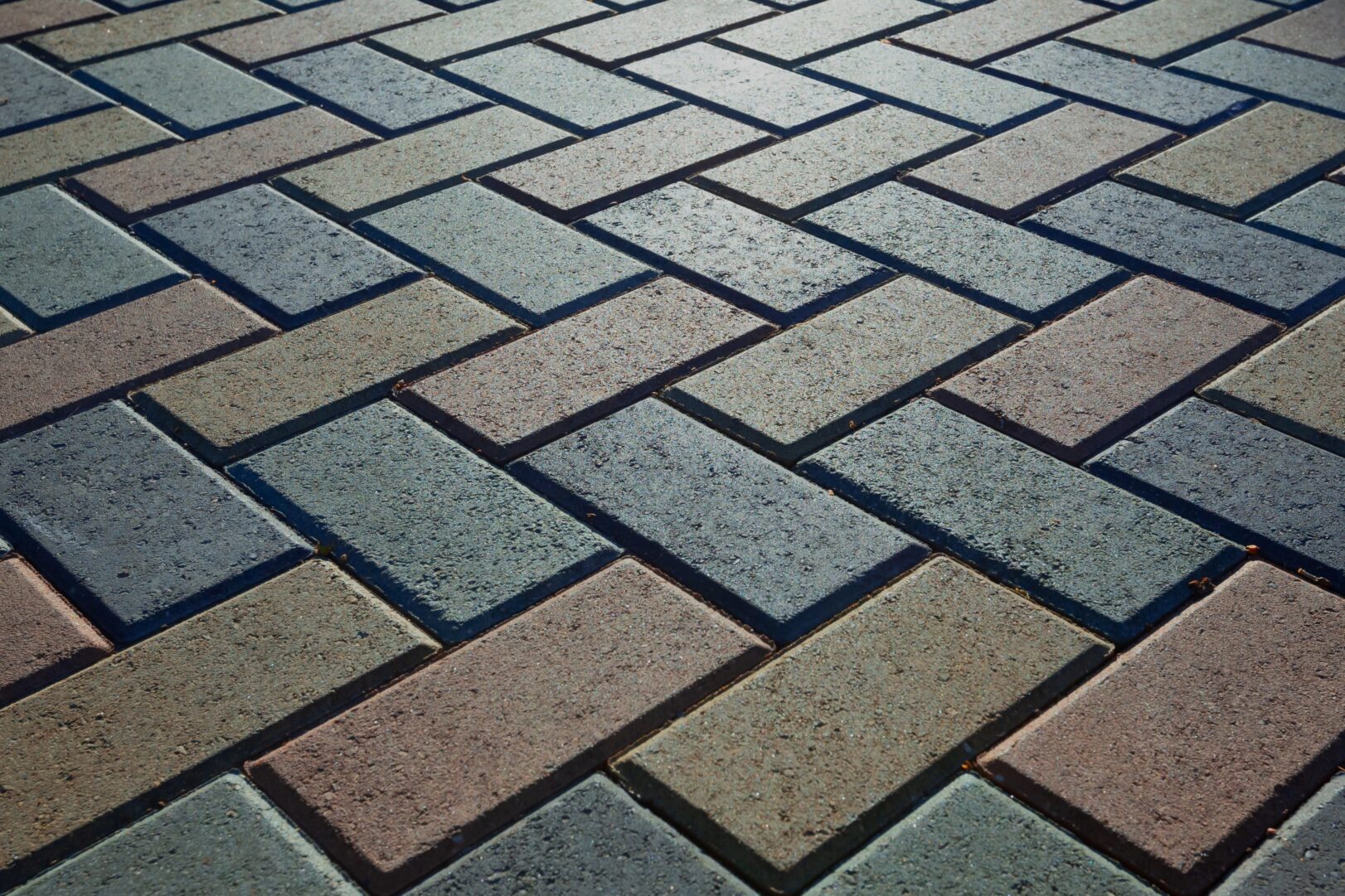 Background - colorful cobblestone pavement of the new paving stones. Diminishing perspective. Backlight.