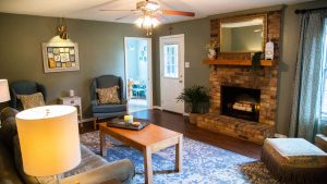 Updated family room with green walls and dark wood floors