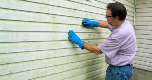man cleaning siding