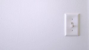 Single-pole light switch on a white wall