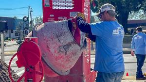 Man pours concrete mix into a mixer