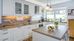 Kitchen with ambient lighting including pendant lights, natural light and under cabinet lighting